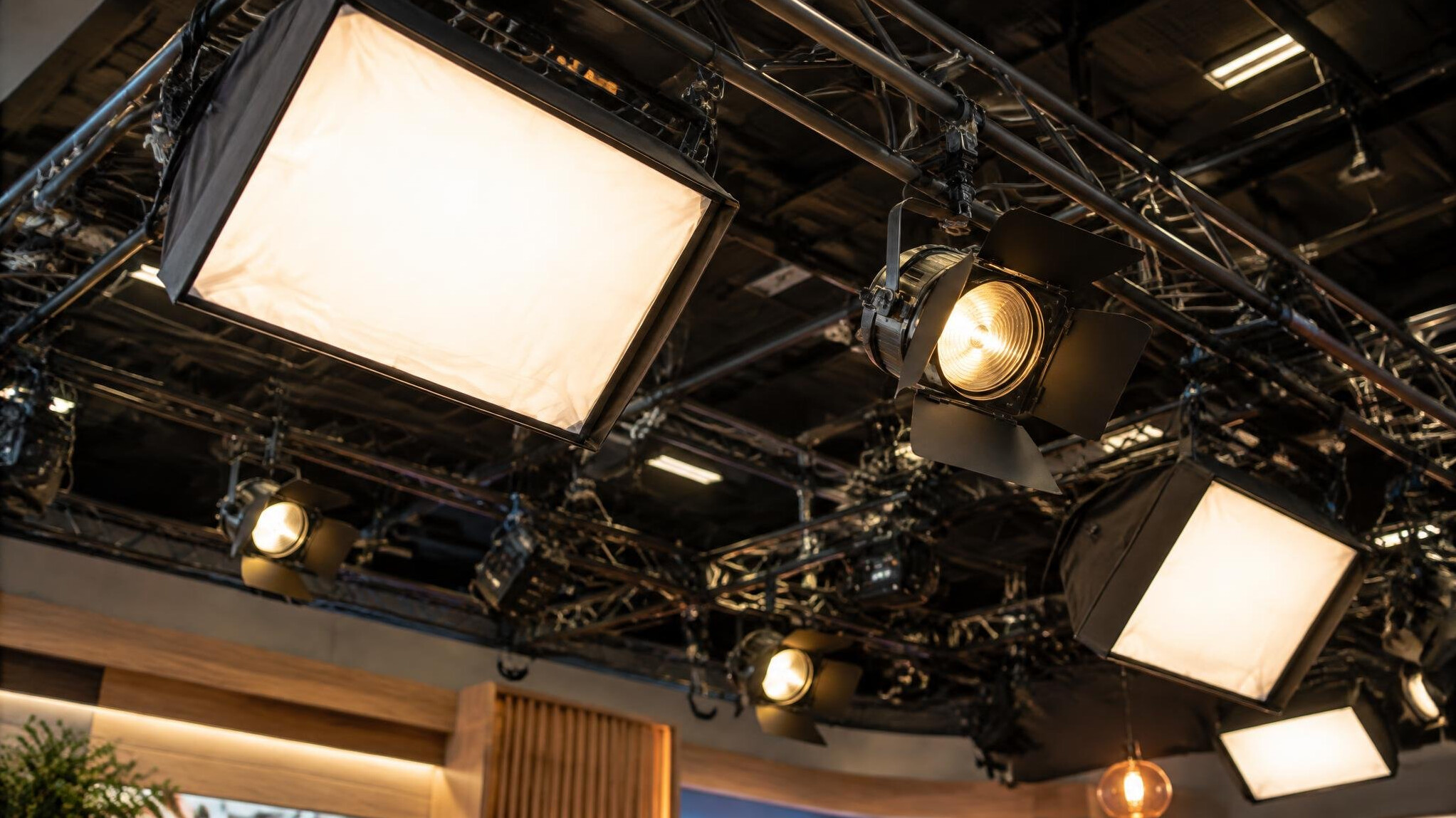 Overhead studio lighting rig above a television set